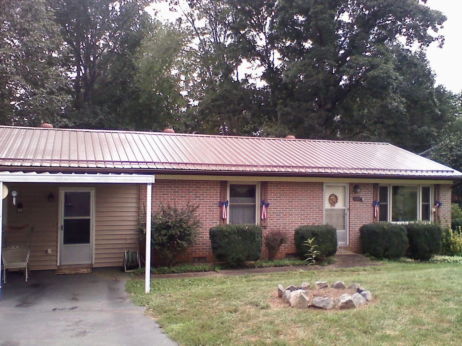 Bronze metal roof and carport on a brick ranch home — Roof Repair work by our crew in Taylors