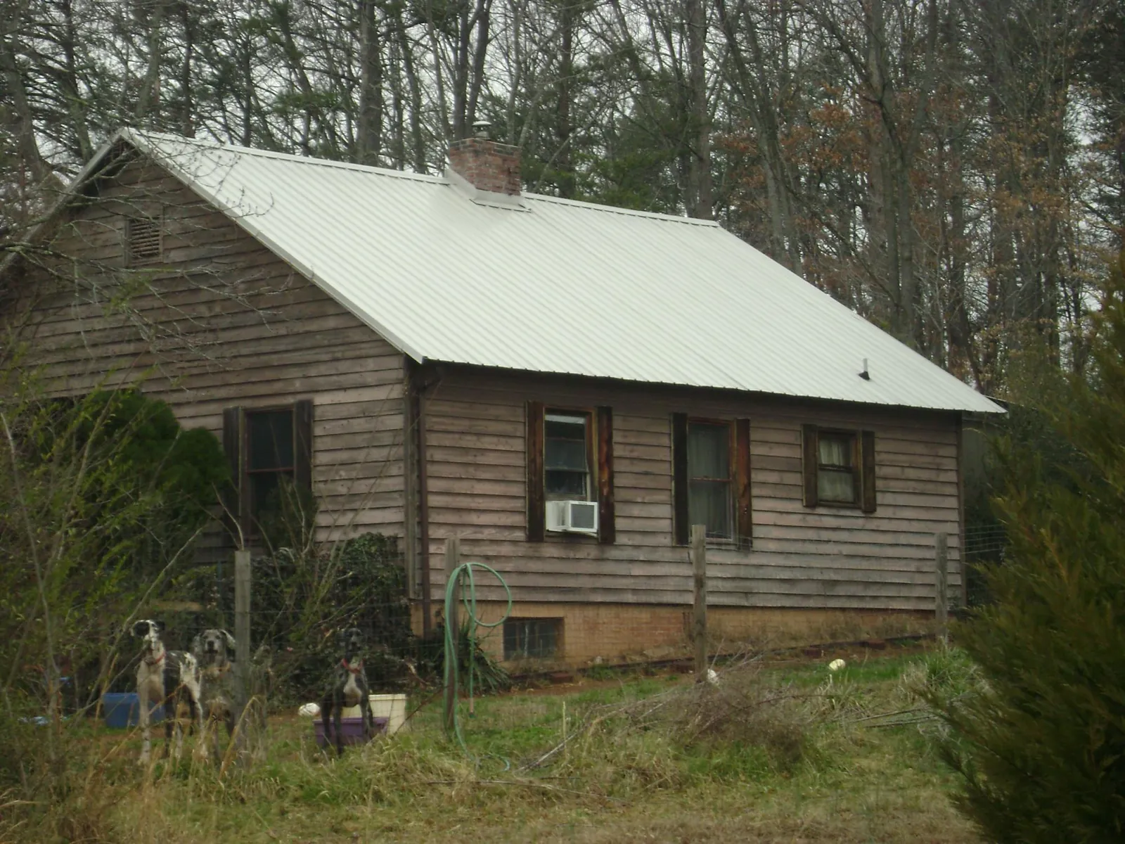 White metal roof on an old wood sided farmhouse, from a Metal Roof Installation job in Taylors